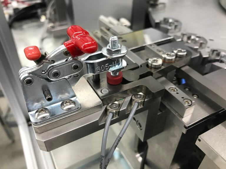 A commercial toggle clamp is used to help retain a custom piece of changeover tooling.